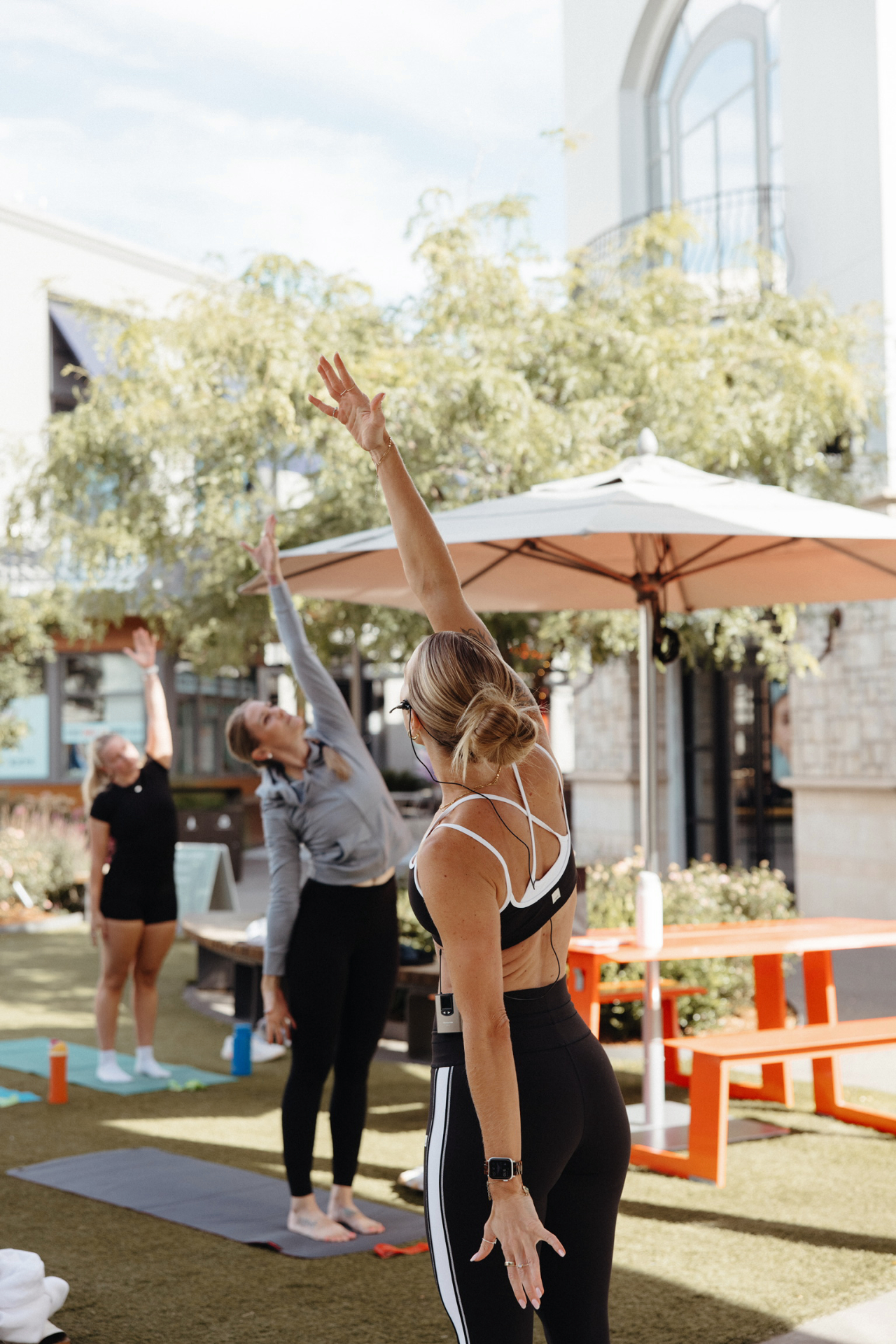 Kelli Blake guiding a side bend stretch outdoors
